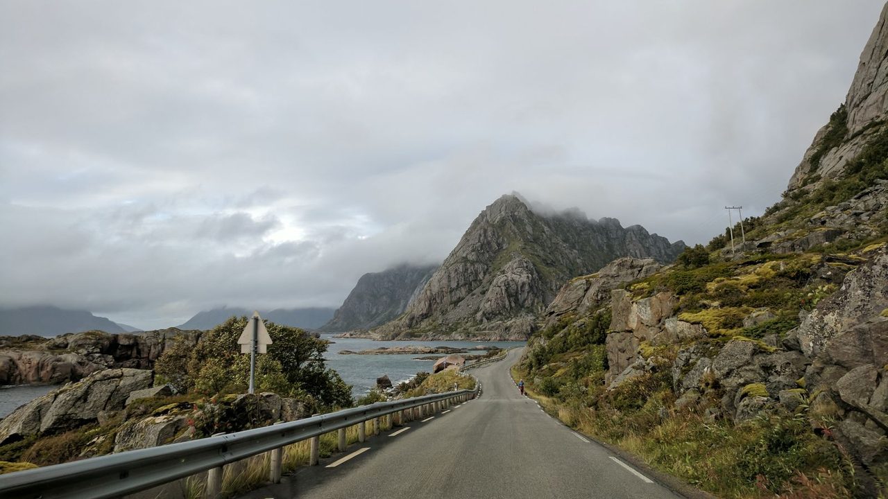 Empty mountain road under a cloudy sky.