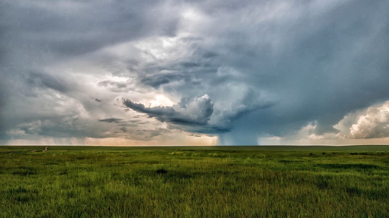 Dark storm clouds over an open field.